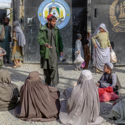Familiares de presos esperan para visitar a sus seres queridos en una entrada de la prisión central de Kandahar, en Kandahar. | Foto:BULENT KILIC / AFP