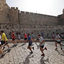Los participantes corren cerca de la puerta de Jaffa en la ciudad vieja de Jerusalén durante el 10º Maratón de Jerusalén. | Foto:EMMANUEL DUNAND / AFP