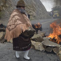 Una mujer indígena bloquea una carretera que une la costa y la sierra, cerca de Zumbahua, en Ecuador, antes de una protesta contra las políticas económicas del gobierno, incluida la subida del precio del combustible, en medio del estado de emergencia. | Foto:RODRIGO BUENDIA / AFP