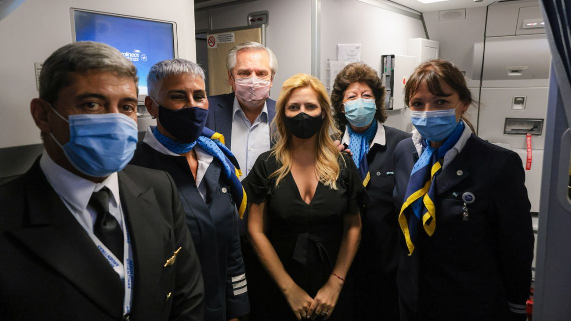 President Alberto Fernández and First Lady Fabiola Yáñez pose for a photograph with the flight crew of the plane taking his to Rome for the G20 Leaders Summit.