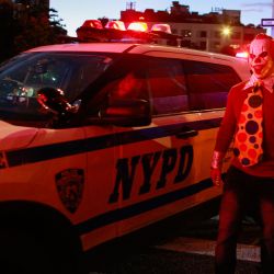 Un coche de la policía de Nueva York pasa por delante de personas disfrazadas que participan en el desfile anual de Halloween del West Village en Nueva York. | Foto:KENA BETANCUR / AFP