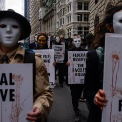 Activistas climáticos con máscaras marchan durante una protesta contra la financiación de los combustibles fósiles por parte de la Reserva Federal, y para conmemorar el 9º aniversario del huracán Sandy, en Nueva York. | Foto:ED JONES / AFP