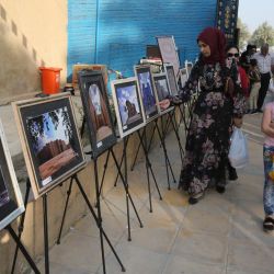 Visitantes observan una exposición fotográfica en el yacimiento arqueológico de la antigua Babilonia durante el Festival Internacional de Babilonia, a unos 100 kilómetros al sur de la capital iraquí. | Foto:SABAH ARAR / AFP