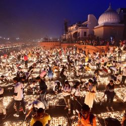 La gente enciende lámparas de tierra en las orillas del río Sarayu durante las celebraciones de Deepotsav en la víspera del festival hindú de Diwali en Ayodhya. | Foto:SANJAY KANOJIA / AFP