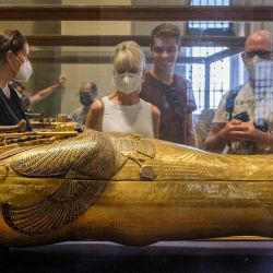 Turistas observan el sarcófago de oro macizo de Tutankamón en la galería dedicada al faraón en el Museo Egipcio en el centro de la capital de Egipto, El Cairo. | Foto:AMIR MAKAR / AFP