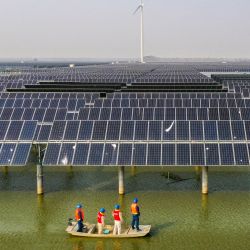 Vista aérea de trabajadores eléctricos patrullando en medio de un proyecto de generación energía fotovoltaica y eólica instalado sobre aguas pesqueras en el poblado de Sheyanghu del distrito de Baoying de Yangzhou, en la provincia de Jiangsu, en el este de China. | Foto:Xinhua/Li Bo