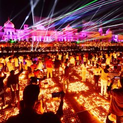 La gente observa un espectáculo de láser en las orillas del río Sarayu durante las celebraciones de Deepotsav en la víspera del festival hindú de Diwali en Ayodhya. | Foto:SANJAY KANOJIA / AFP