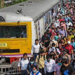 Los pasajeros caminan por un andén después de salir de un tren de cercanías en Calcuta, ya que los servicios ferroviarios reanudaron la normalidad después de circular con las restricciones impuestas anteriormente para frenar la propagación del coronavirus Covid-19. | Foto:DIBYANGSHU SARKAR / AFP