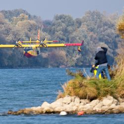 Un avión de extinción de incendios Canadair CL-415, procedente de Italia, se prepara para tomar agua del río Neue Donau, en un distrito del norte de Viena, con el fin de extinguir un incendio forestal declarado en Hirschwang, en la localidad de Reichenau an der Rax, en Austria. | Foto:GEORG HOCHMUTH / APA / AFP