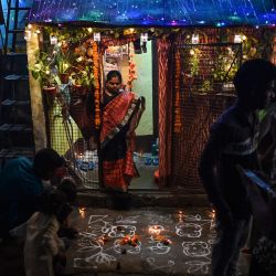 Un padre se prepara para encender una bengala con sus hijos fuera de su casa mientras celebran el festival hindú Diwali o el Festival de las Luces en Nueva Delhi. | Foto:Sajjad Hussain / AFP