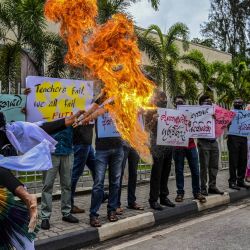 Una persona que acompaña a los profesores realiza un truco de soplado de llamas durante una manifestación para exigir mayores salarios frente a la Universidad Abierta de Sri Lanka (OUSL) en Colombo. | Foto:ISHARA S. KODIKARA / AFP