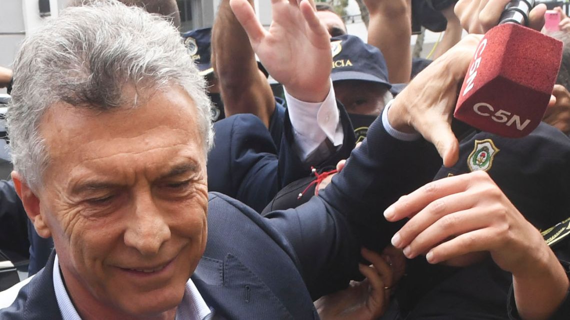 Former president Mauricio Macri grabs a C5N television channel microphone before attending a court hearing in Dolores.