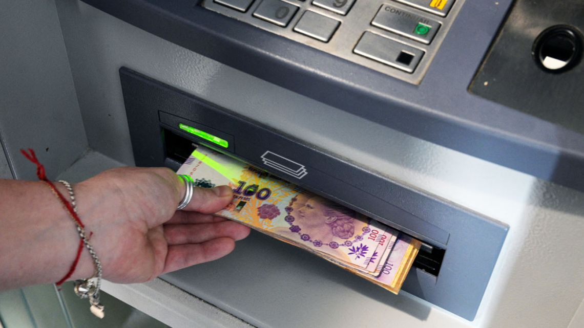 Pesos are withdrawn from a cashpoint in Buenos Aires City.