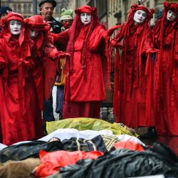 Miembros de la Brigada Rebelde Roja, un grupo internacional de artivistas, participan en una protesta "Die In" frente a las oficinas de Mercer Asset Management en George Square, Glasgow, durante la Conferencia de las Naciones Unidas sobre el Cambio Climático COP26. | Foto:Andy Buchanan / AFP