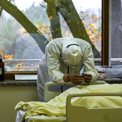 Un miembro del personal médico descansa junto a un paciente infectado por el virus Covid-19 en la unidad de cuidados intensivos del hospital Lozenets de Sofía. - Bulgaria se encuentra entre los países con mayor número de muertes en comparación con su población. | Foto:NIKOLAY DOYCHINOV / AFP