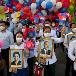 La gente sostiene fotos de retratos del ex rey Norodom Sihanouk y la ex reina Monique en el Monumento a la Independencia durante una ceremonia que marca el Día de la Independencia de Camboya en Phnom Penh. | Foto:TANG CHHIN SOTHY / AFP