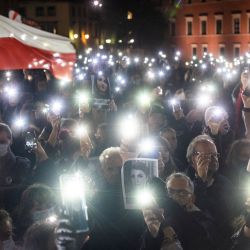 Manifestantes sostienen luces, una bandera polaca y una fotografía de Iza mientras participan en una manifestación en Varsovia, Polonia, para conmemorar el primer aniversario de una sentencia del Tribunal Constitucional que impuso una prohibición casi total del aborto, y también para conmemorar la muerte de la mujer polaca embarazada Iza. | Foto:WOJTEK RADWANSKI / AFP