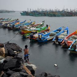 Los pescadores amarran su barco con cuerdas en el puerto pesquero de Kasimedu durante una lluvia monzónica en Chennai, India. | Foto:ARUN SANKAR / AFP