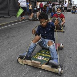Niños y adolescentes participan en una carrera de carritos artesanales de madera en una calle, en la parroquia Altagracia, en Caracas, Venezuela. | Foto:Xinhua/Str