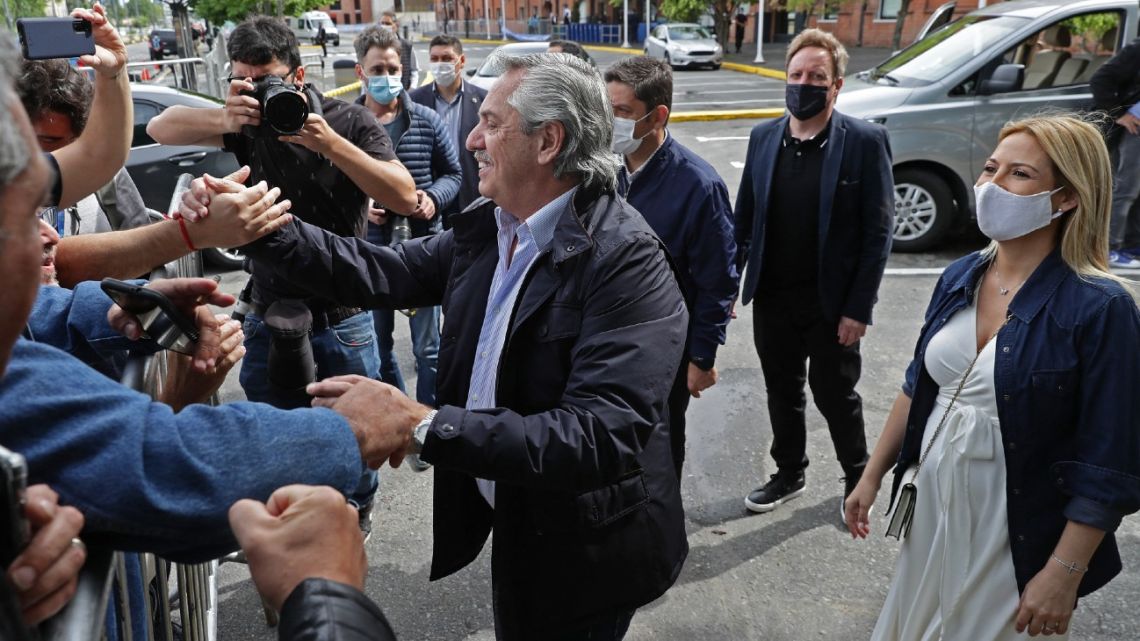 President Alberto Fernández, accompanied by his pregnant wife, First Lady Fabiola Yáñez, greets supporters after casting his vote at a polling station during midterm congressional elections, in Buenos Aires, on November 14, 2021. 