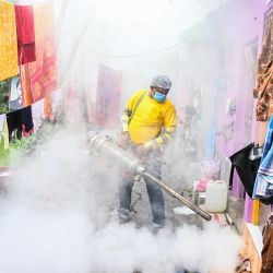 Un trabajador municipal fumiga una zona de chabolas como medida preventiva contra las enfermedades causadas por los mosquitos en Calcuta. | Foto:DIBYANGSHU SARKAR / AFP