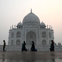 Los visitantes caminan por el interior del Taj Mahal en medio de la niebla tóxica mientras sale el sol en Agra, India. | Foto:Sajjad Hussain / AFP