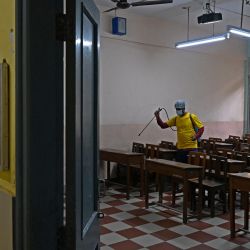 Un trabajador municipal desinfecta un aula en una escuela de Calcuta después de que el gobierno estatal anunciara la reapertura de los centros educativos que fueron cerrados como medida preventiva contra la propagación del coronavirus Covid-19. | Foto:DIBYANGSHU SARKAR / AFP