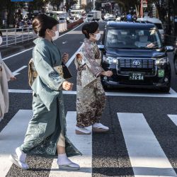 Mujeres vestidas con kimonos tradicionales cruzan una calle en la zona de Ginza, en Tokio. | Foto:CHARLY TRIBALLEAU / AFP