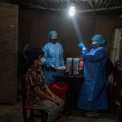 Un trabajador de la salud se prepara para inocular a un hombre con una dosis de la vacuna de Pfizer-BioNTech contra el COVID-19, en el distrito de Santa Anita, en la periferia oriental de Lima. | Foto:ERNESTO BENAVIDES / AFP