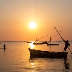 Un pescador mueve su barco al amanecer frente a la costa del barrio de los pescadores en la ciudad de Maputo, Mozambique. | Foto:Alfredo Zuniga / AFP