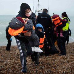 Una migrante lleva a sus hijos tras ser ayudada a tierra desde un bote salvavidas de la RNLI (Royal NationalLifeboatInstitution) en una playa de Dungeness, en la costa sureste de Inglaterra. AFP | Foto:AFP