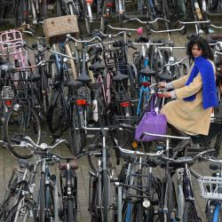 Una mujer monta una bicicleta en una bicicleta fuera de estacionamiento en Amsterdam, Holanda occidental.  | Foto:AFP