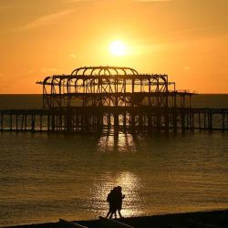 El sol se pone en el horizonte más allá de los restos del West Pier cerca de la playa de Brighton, en Brighton, en el sur de Inglaterra.  | Foto:AFP