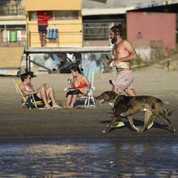 Un hombre trota junto a su mascota en la playa Ramírez, en Montevideo, capital de Uruguay | Foto:Xinhua News Agncy