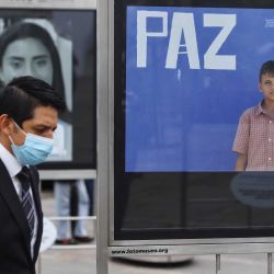 Un hombre camina frente a una exposición fotográfica durante la feria  | Foto:Xinhua News Agncy