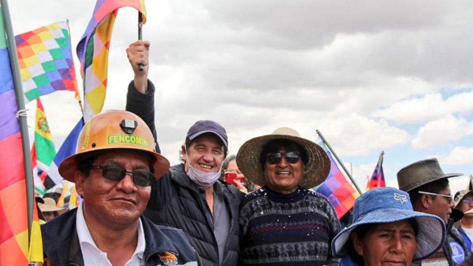 El embajador argentino en Bolivia, Ariel Basteiro, con una bandera del MAS junto a Evo Morales en una marcha en Bolivia.