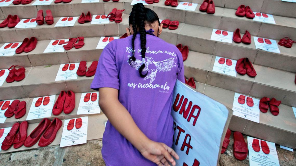 A girl observes a tribute to victims of femicide during International Day for the Elimination of Violence Against Women, outside the Supreme Court of Justice in Panama City.