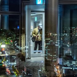 El reflejo de un visitante se ve en una ventana mientras el horizonte de la ciudad de Sendai se ve al atardecer desde la plataforma de observación del edificio AER. | Foto:Philip Fong / AFP