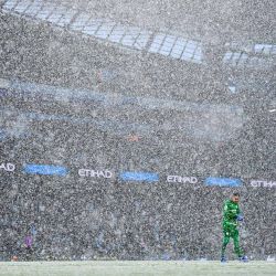 El arquero brasileño del Manchester City, Ederson, es visto mientras cae la nieve durante el partido de fútbol de la Premier League inglesa entre el Manchester City y el West Ham United en el Etihad Stadium en Manchester, noroeste de Inglaterra. | Foto:OLI SCARFF / AFP