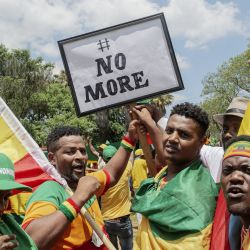 Etíopes residentes en Sudáfrica gritan consignas mientras uno de ellos sostiene una pancarta durante una protesta ante la embajada de Estados Unidos en Pretoria, contra la supuesta injerencia extranjera en Etiopía. | Foto:LUCA SOLA / AFP