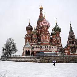 Un peatón con paraguas pasa por delante de la catedral de San Basilio en el centro de Moscú durante una nevada. | Foto:KIRILL KUDRYAVTSEV / AFP