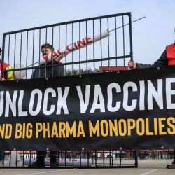 Activistas protestan a favor de un acuerdo para suspender la protección de las patentes de las vacunas Covid-19 en Ginebra. | Foto:FABRICE COFFRINI / AFP