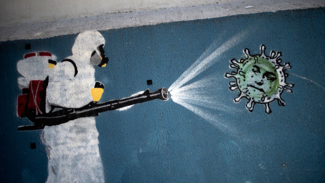 File photo of a mural depicting a man in protective suit spraying disinfectant on a coronavirus with Brazilian President Jair Bolsonaro's face, at the Tijuca neighborhood in Rio de Janeiro, Brazil, amid the new coronavirus pandemic. Brazil confirmed the third case of the new COVID-19 variant, omicron, in a traveller coming from Ethiopia, authorities confirmed on December 1, 2021. 