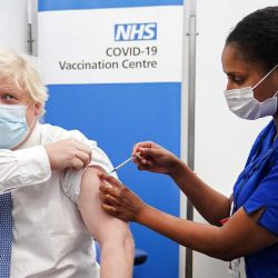 El primer ministro británico, Boris Johnson, recibe su inyección de refuerzo de covid-19 de manos de la enfermera, Saffron, en una clínica de vacunación en el Hospital St Thomas, en el centro de Londres. | Foto:Paul Edwards / POOL / AFP