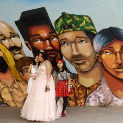 Niñas posan junto a una quinceañera frente a un mural, en el distrito de Barranco, en Lima, Perú. | Foto:Xinhua/Mariana Bazo