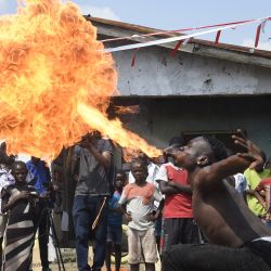 Una persona escupe fuego durante una fiesta en un barrio marginal de Lagos, Nigeria. | Foto:PIUS UTOMI EKPEI / AFP