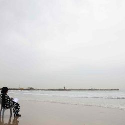 Una mujer palestina escribe sentada junto al mar Mediterráneo en la playa de la ciudad de Gaza. MOHAMMED ABED  | Foto:AFP