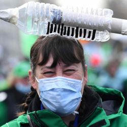 Una trabajadora de la salud lleva un objeto simbólico con forma de jeringa en la cabeza mientras participa en una manifestación sindical contra la vacunación obligatoria contra el Covid 19, como parte de un gran día de acción, en Bruselas. JOHN THYS  | Foto:AFP