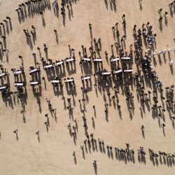 Una fotografía aérea muestra a los dolientes llevando ataúdes durante un funeral masivo por las víctimas yazidíes del grupo Estado Islámico, cuyos restos fueron encontrados en una fosa común, en la aldea de Kojo, en el norte de Irak, en el distrito de SinjarZaid. | Foto:AFP