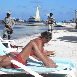 Turistas disfrutan de su tiempo libre mientras elementos de la Guardia Nacional participan en un operativo para reforzar la seguridad en Playa Langosta, en Cancún, estado de Quintana Roo, México | Foto:Xinhua